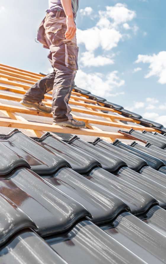 Mann bei Dachdeckerarbeiten